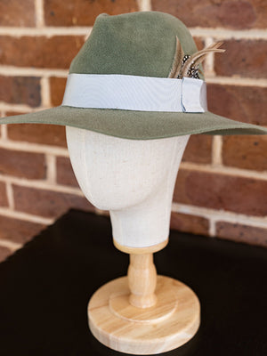 Side view of soft green felt fedora hat with beige coloured feathers.