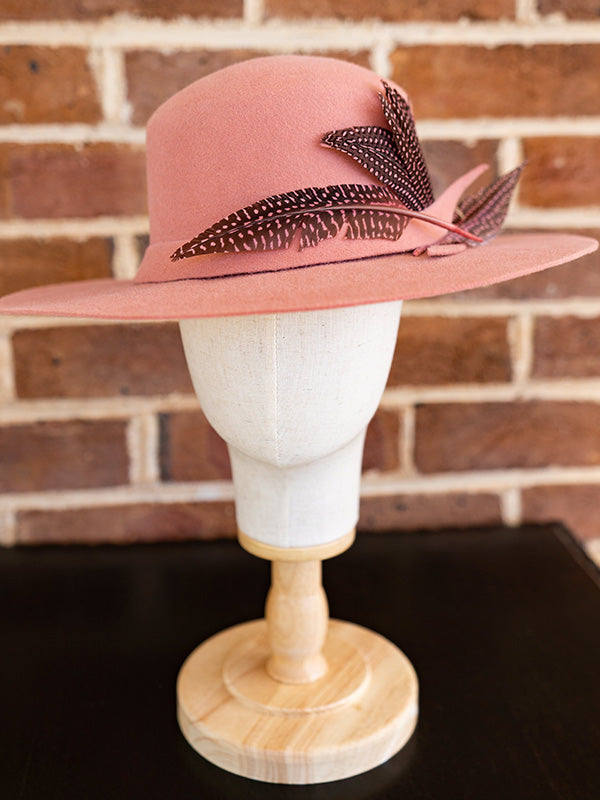 Front view of salmon pink felt hat trimmed with spotty pink dyed feathers.