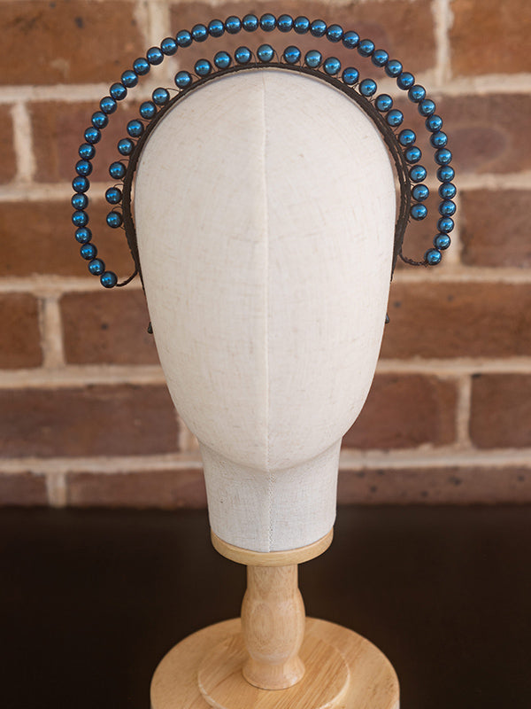 Front view of blue beaded headpiece. The beads sit over two lines and curve around the head.