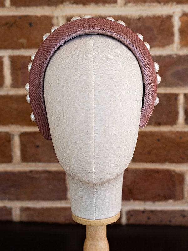 Front view of the dusty pink velvet headband. Faux pearls adorn the headband.