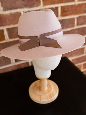 Top view of pink felt fedora hat with three ribbons wrapped around the hat.