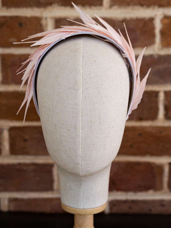 Front view of the soft pink headband. Pink feathers adorn the whole headband.