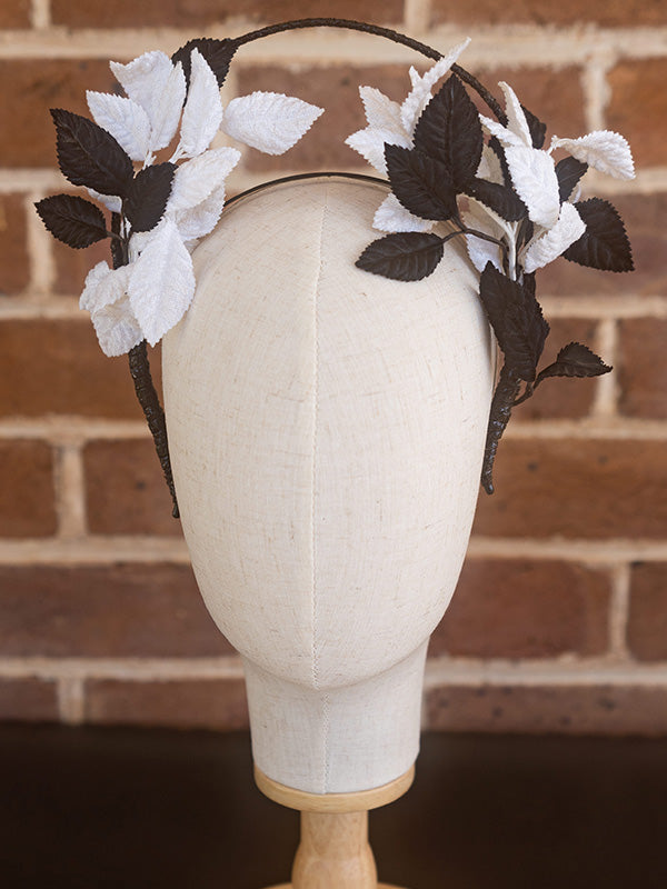 Front view of vintage black and white leaf headpiece. The leaf design is on either side of the headband.
