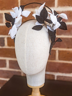Side view of vintage black and white leaf headpiece. The leaf design is on either side of the headband.