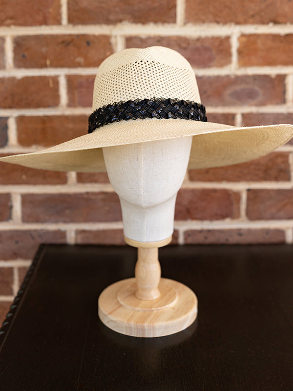 Front view of the wide brimmed natural panama hat and black trim.